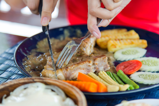 肉を食べる女性の写真