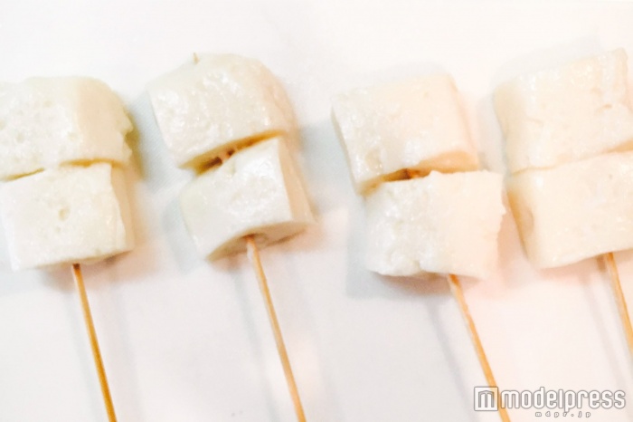 固まったお餅を竹串にさす（C）モデルプレス