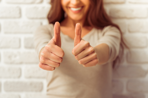 両手でグッドサインを表している女性の写真