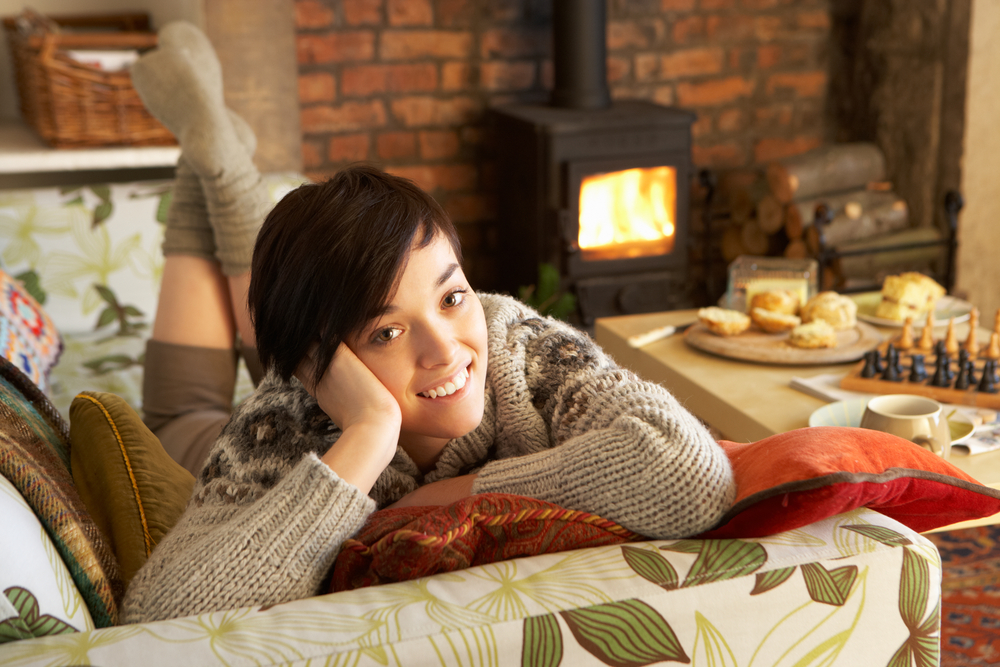 Young woman relaxing by fire