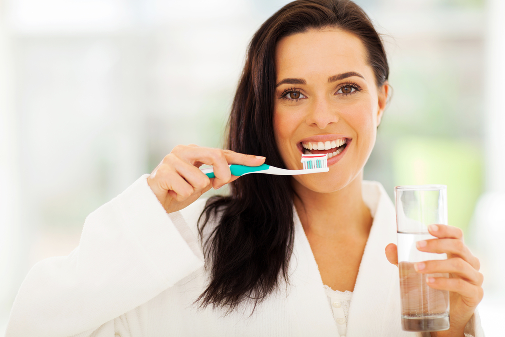close up portrait of cute woman brushes her teeth