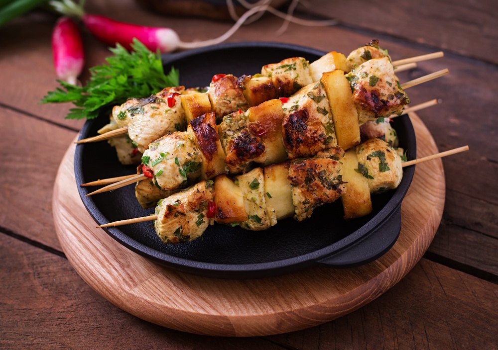 Chicken skewers with slices of apples and chili